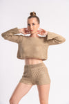 Female model in a beige knitted crop top and shorts