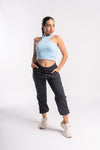 woman wearing gym clothes of blue crop tank top and black jogger pants