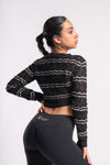 Woman wearing a textured cropped knit top with intricate patterns.