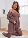 ribbed lounge set with a camisole, cardigan, and drawstring pants, posing while holding a phone in a cozy indoor setting