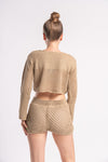 Stylish woman in a light brown crochet outfit