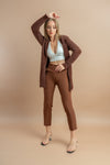 A woman in brown trousers exuding a chic and casual vibe