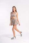 Sporty beige outfit with a cropped, collared top and a pleated skirt, ideal for workouts