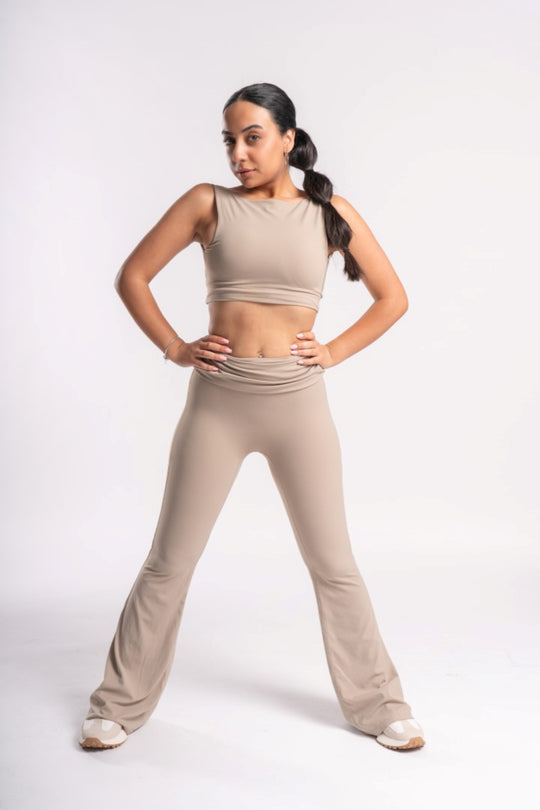 woman in beige color crop top and flared leg yoga pants set for workout session