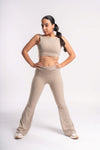 woman in beige color crop top and flared leg yoga pants set for workout session