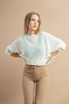 Soft white sweater with batwing sleeves, perfect for a chic and comfortable look.