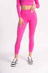 woman wearing fitness set of pink color yoga leggings and full sleeves cropped top