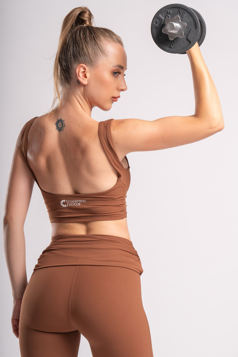 Model in backless crop top and high-waist yoga pants with a flared silhouette