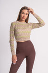 Fashion model wearing a beige and green detailed sweater crop top