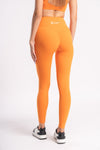 orange color workout wear yoga pants with high waist and broad waistband for comfort