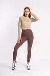 woman ready for yoga session with the perfect brown yoga leggings and beige crop top