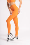 women wearing active wear of orange color as high waist yoga pants and matching sports bra set