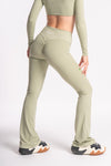 woman wearing a sage green high waist yoga pants and full sleeves top wear full set