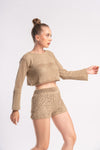 Woman modeling a beige crochet shorts and crop top set