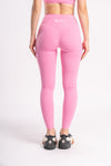 woman wearing pink color sports leggings with breathable fabric and stretchable fabric