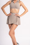 Beige athletic set for women with a cropped, collared top and pleated skirt for workouts