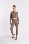 A model showcases a stylish brown cropped top paired with matching leggings