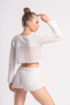 woman wearing a crop top and short set of white color made up of breathable mesh crocheted fabric