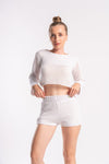 Woman in a white mesh two-piece outfit perfect for a lounge party