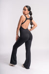 side pose of a woman wearing active wear jumpsuit of black color with backless stylish look