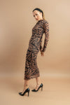 Elegant woman in a form-fitting animal-print dress with long sleeves