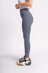 woman in side pose with gym wear sports leggings of grey color