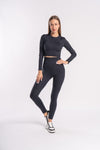 a set of black color full sleeves cropped top and yoga pants with sports shoes