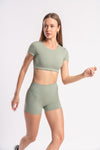 Stylish gym outfit for women in olive green crop top and shorts