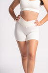 Women’s sleek white gym set with high-waist shorts and matching sports bra