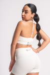 White gym outfit for women with high-waisted shorts and racerback sports bra